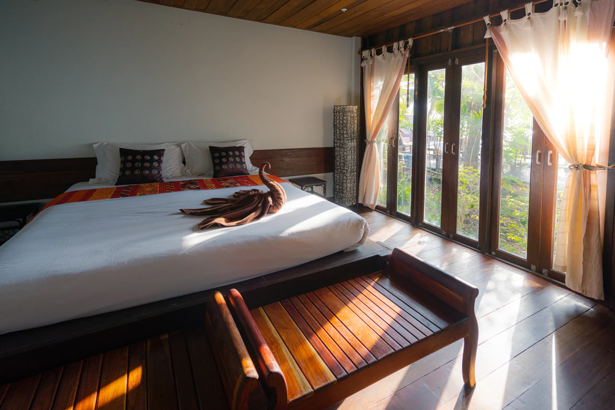A bright treatment room with a bed and daylight through wide doors.
