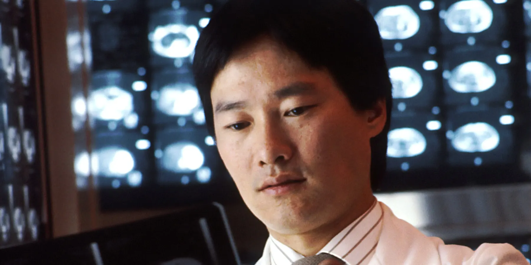 A radiologist reading films against a bank of viewing boxes.