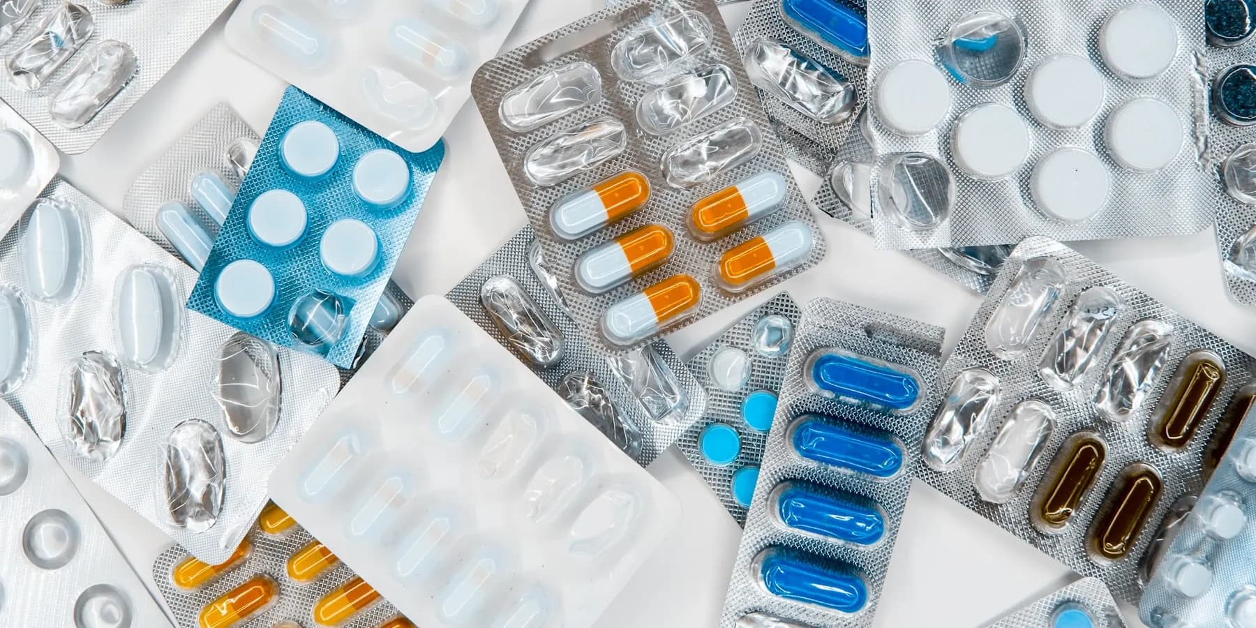 Blister packs of tablets laid out on a bench.