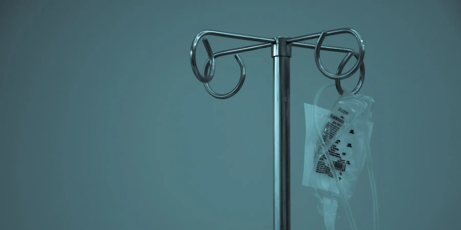 An infusion stand and a hanging bag in a day care bay.