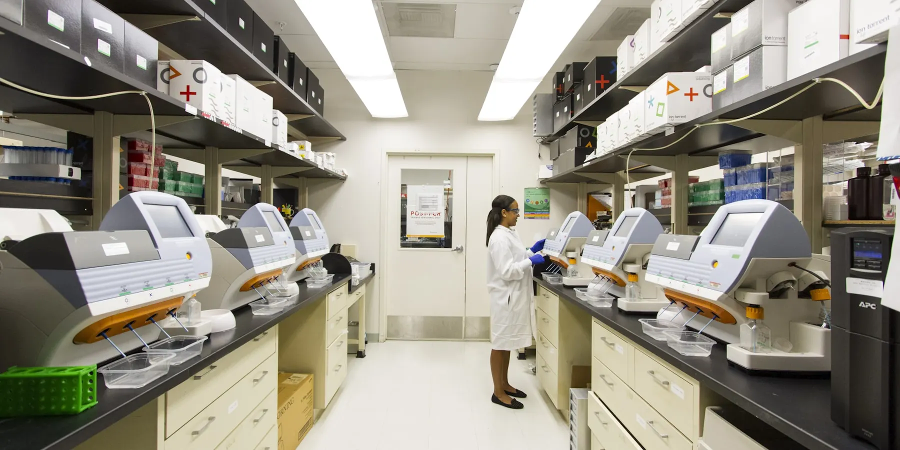 A row of automated analysers along a laboratory bench.