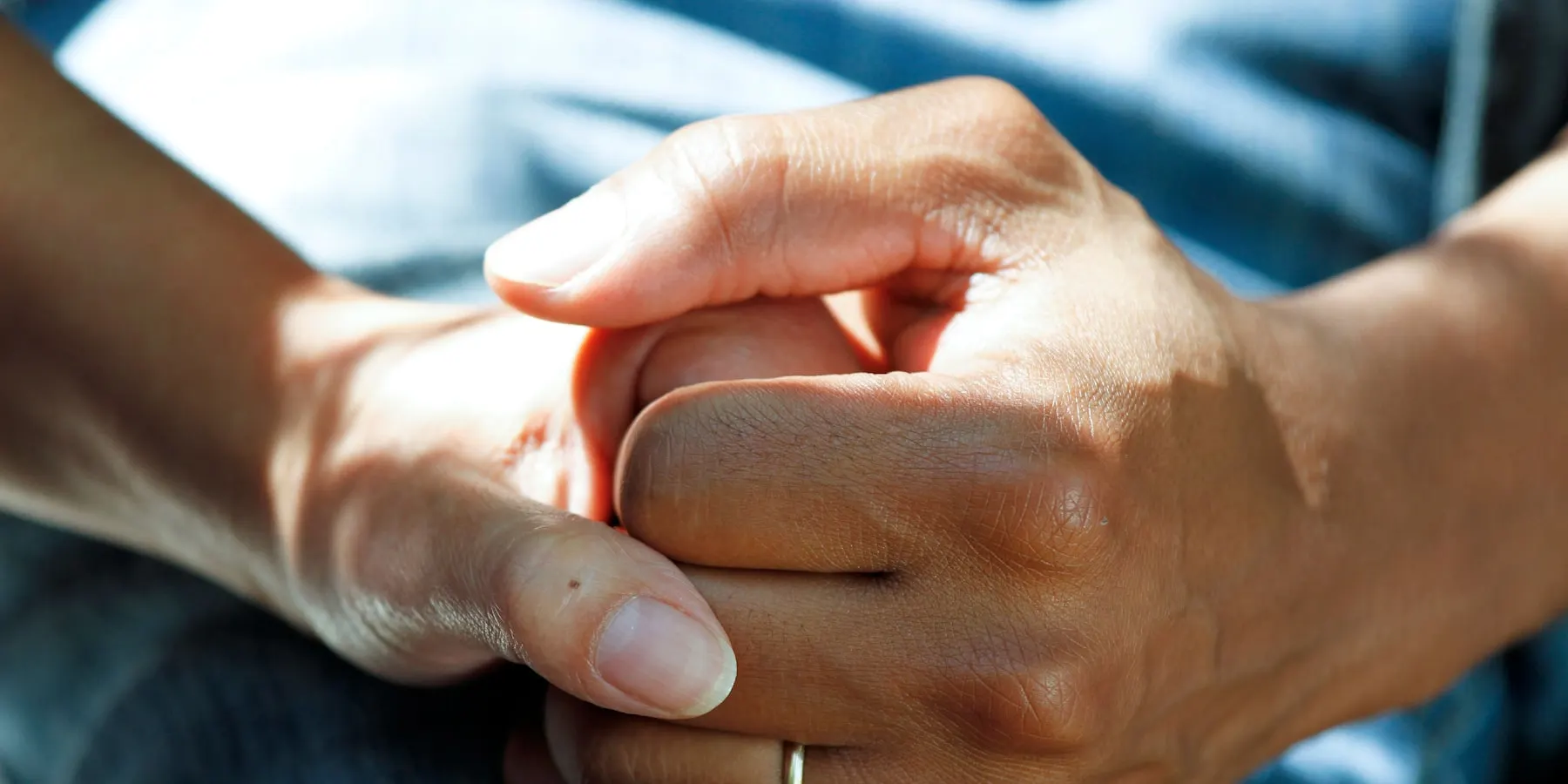 Two hands held, one supporting the other.