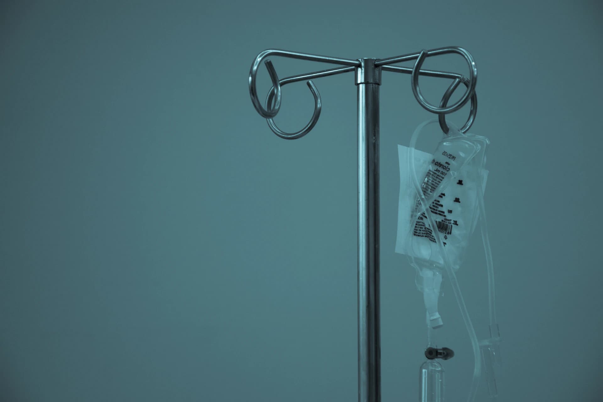 An infusion stand beside a bed.