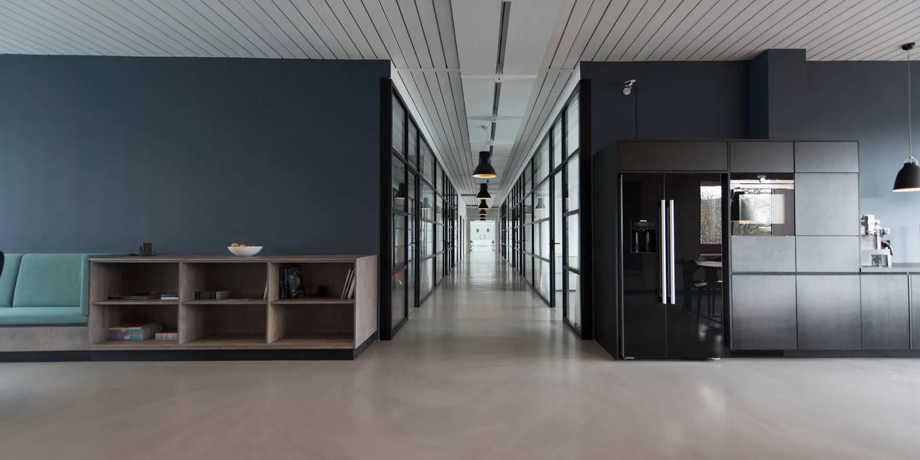 A quiet, empty interior corridor with daylight along one side.