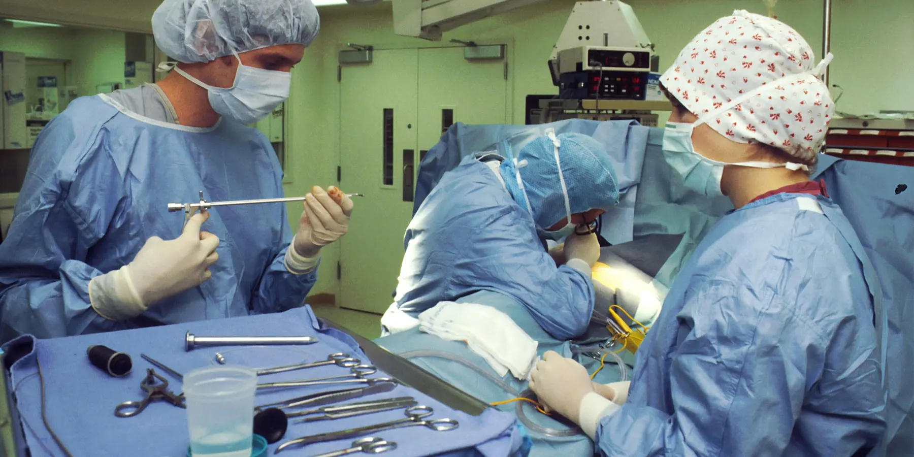 A laid instrument tray beside an operating table, mid case.