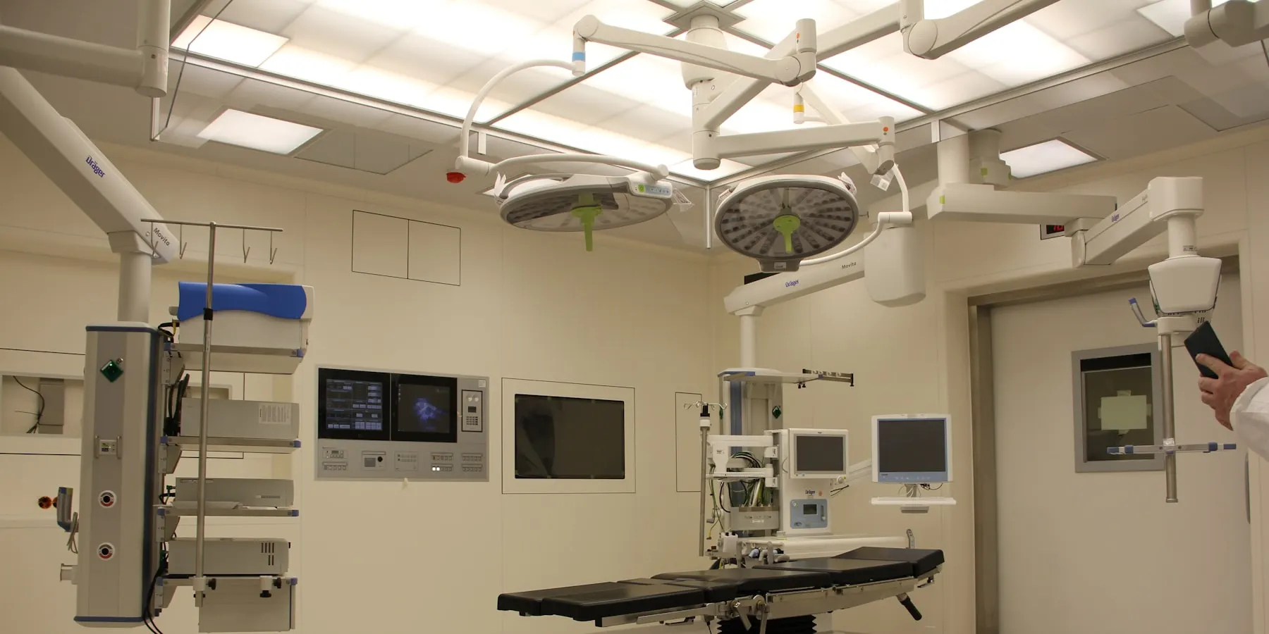 An operating theatre between cases, lights parked and table clear.
